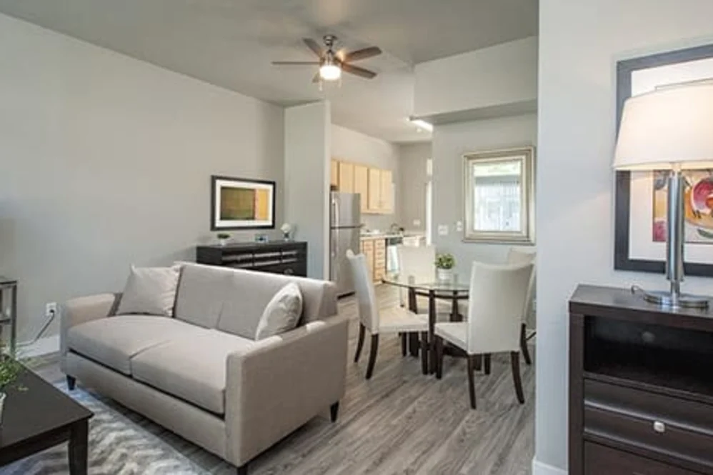 Renovated apartment living room and dining area with sofa, round dining table, and hardwood floors